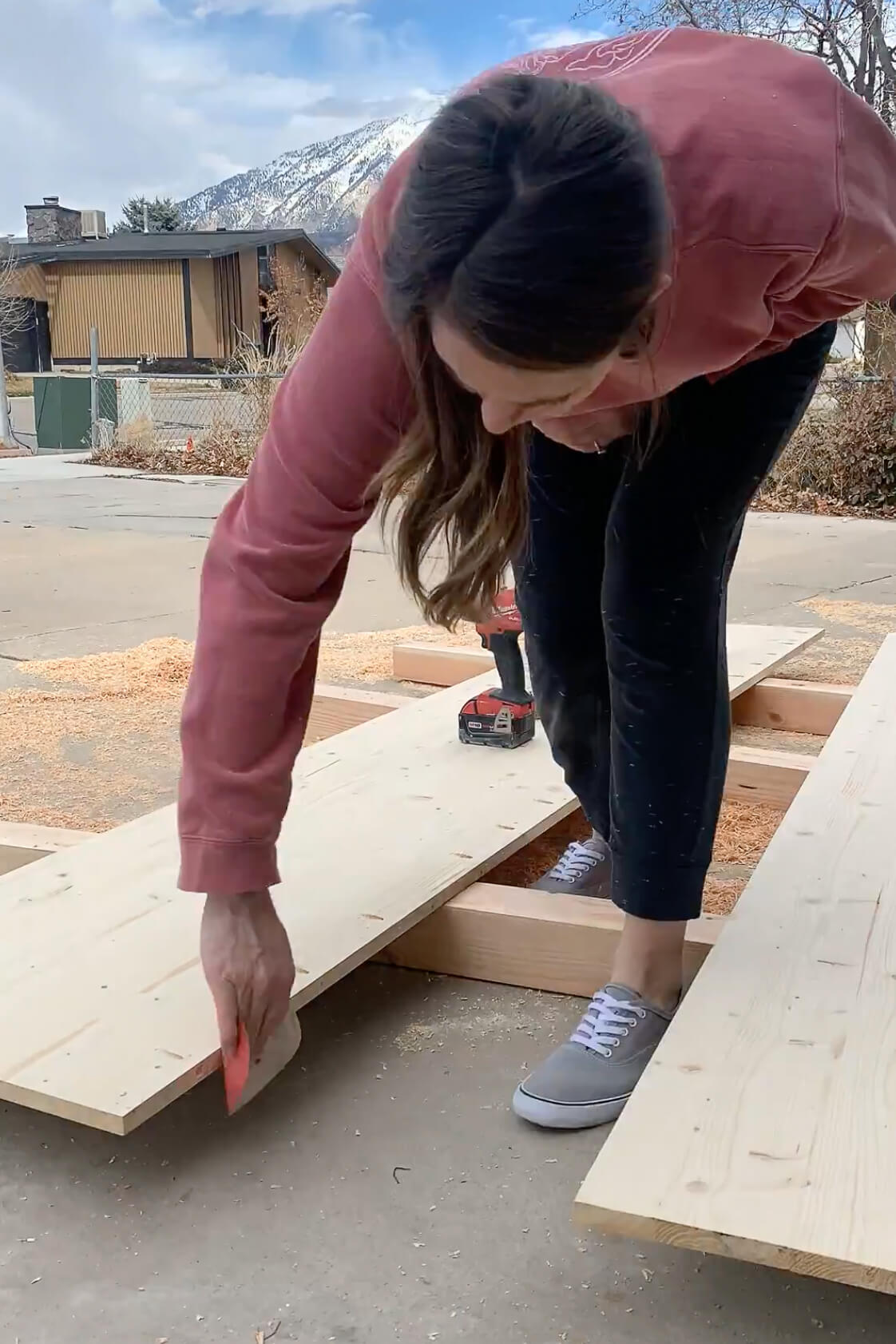 Using wood glue to attach two pieces of wood together for a DIY table top.